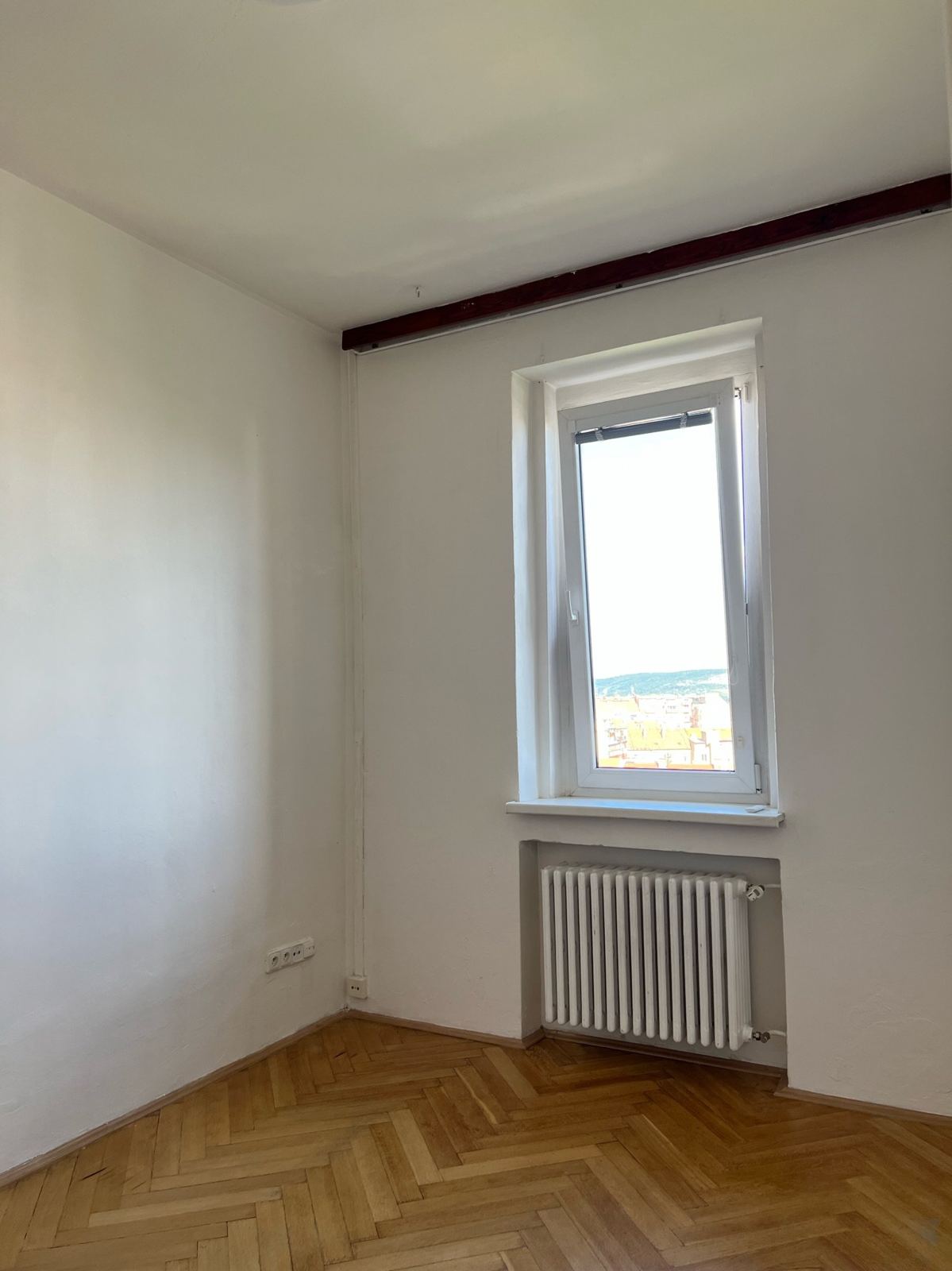 Menší pokoj, okno a radiátor